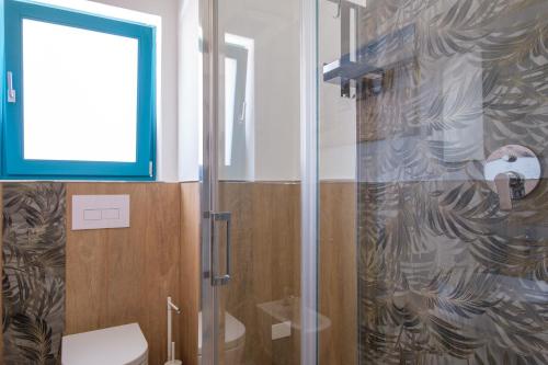 a bathroom with a shower with a toilet and a window at Eos affittacamere in Castelsardo