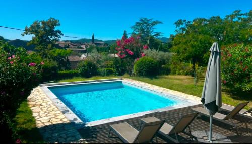 une piscine avec des chaises et un parasol dans l'établissement Maison de Charme Sud Ardèche, à Vallon-Pont-dʼArc
