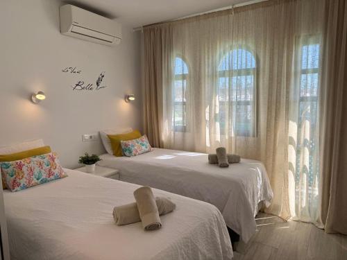 a bedroom with two beds with towels on them at Bungalow Dunaflor Verde 4 in San Bartolomé