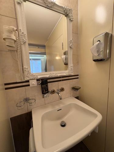 a white sink in a bathroom with a mirror at Esos Hotel Quelle in Bad Ragaz