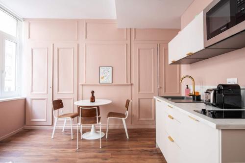 - une cuisine avec une table et des chaises blanches dans la chambre dans l'établissement L'Élysia - Charmant T2 au coeur du Vieux-Lille, à Lille