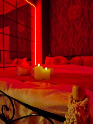 a bedroom with a bed with two candles on it at Saints & Sinners Romantic Jacuzzi in Bucharest