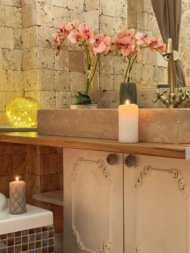 a counter with two candles and flowers on it at Saints & Sinners Romantic Jacuzzi in Bucharest