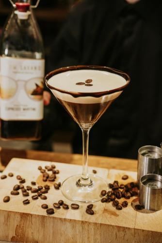 a martini glass sitting on a wooden table with coffee beans at Stallingborough Grange Hotel in Stallingborough