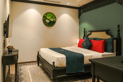 a bedroom with a bed with red and blue pillows at Hanoi Bliss Hotel in Hanoi