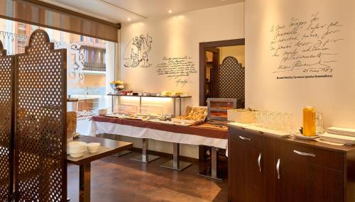 Un restaurante con una mesa con comida encima. en Monjas del Carmen Hotel, en Granada