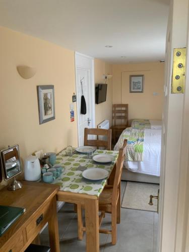 a dining room with a table and a bed at Green Apple Bed and Breakfast in St Ives