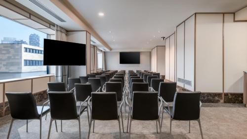 a conference room with chairs and a projection screen at AC Hotel Milano by Marriott in Milan