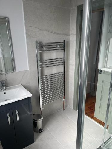 a small bathroom with a shower and a sink at Hill House, panoramic Burren views, ideal location in Kilfenora