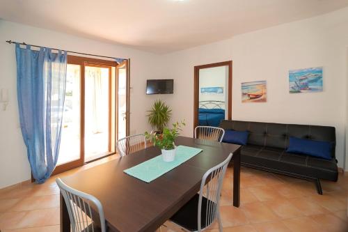 a living room with a table and a couch at Appartamento vicino alla spiaggia -G- in Tanaunella