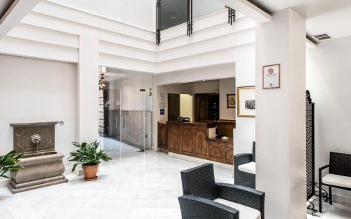a living room with a fireplace and chairs at Monjas del Carmen Hotel in Granada