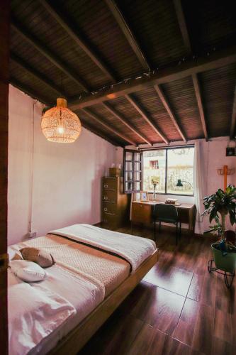 a bedroom with a bed and a desk and a window at Casa Profunda - Santa Elena in Medellín
