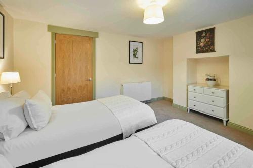 a bedroom with two white beds and a dresser at Host & Stay - St Mary's Riverside in Whitby