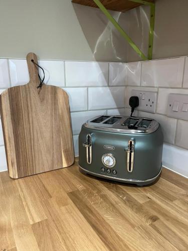 a toaster on a kitchen counter next to a cutting board at Claires Cottage in Bethesda