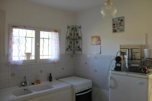 une cuisine avec un évier, une cuisinière et une fenêtre dans l'établissement Gite viticole, à Mollans-sur-Ouvèze