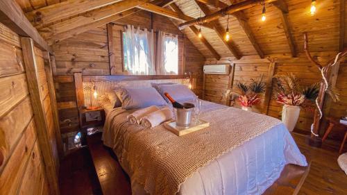 a bedroom with a bed in a wooden cabin at Chalé Morada dos Tucanos in Santo Amaro da Imperatriz