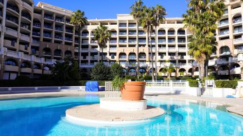 une piscine en face d'un grand bâtiment dans l'établissement Appartement 426, vue mer et piscine by Palmazur, à Cannes