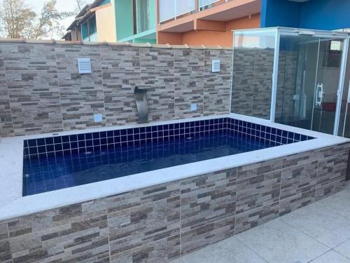 une piscine dans un mur de briques dans l'établissement Unamar, conforto em frente a praia!, à Cabo Frio