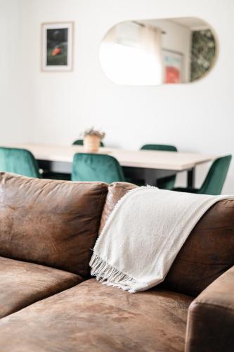 - un canapé brun avec un oreiller blanc dans l'établissement Côte Landaise et Pétanque, à Parentis-en-Born