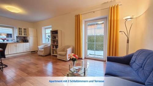 a living room with a blue couch and a table at Urlaubsapartment am Silbersee in Villach