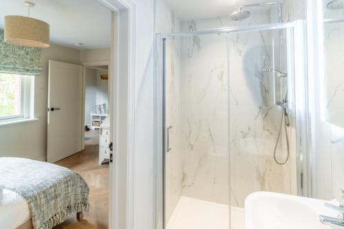 een badkamer met een douche met een glazen deur bij Church Cottage Stiffkey in Stiffkey