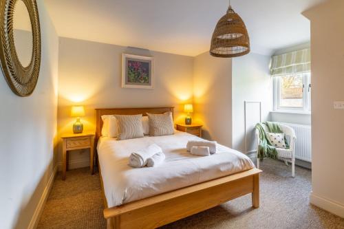 een slaapkamer met een bed met twee handdoeken erop bij Church Cottage Stiffkey in Stiffkey