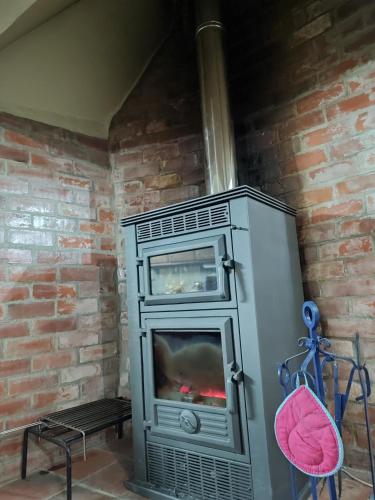 a fireplace in a room with a brick wall at Casa Iris Cunqueiros in Sobreira Formosa