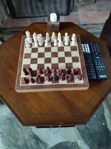 a chess board on a table next to a remote control at Casa Iris Cunqueiros in Sobreira Formosa