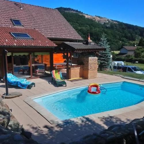 - une piscine avec un jouet en face d'une maison dans l'établissement Les champstousnods, à Lepuix