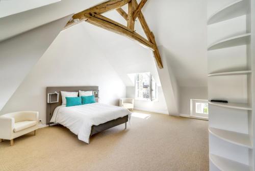 Un dormitorio blanco con una cama y una silla. en Incroyable villa à Amponville avec piscine privée., en Amponville