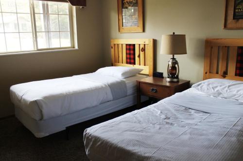 a bedroom with two beds and a table with a lamp at 2 Bedroom Condo at Wild Eagle Lodge, #136 in Eagle River