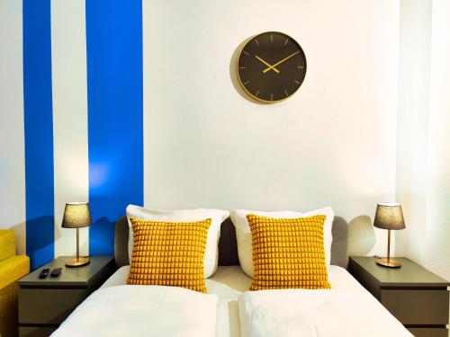 a room with two beds and a clock on the wall at Modernes City-Apartment nahe der Elbe mit Terrasse in Magdeburg