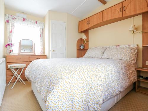 a bedroom with a large bed and a window at 120 Caravan in Great Yarmouth