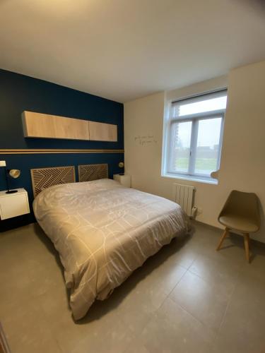 une chambre avec un lit, une chaise et une fenêtre dans l'établissement Maison individuelle avec terrasse et parking, à Sains-lès-Marquion