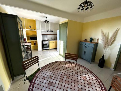 une cuisine et une salle à manger avec une table et des chaises dans l'établissement Appartement pleine nature 5pers - A2, à Grimaud