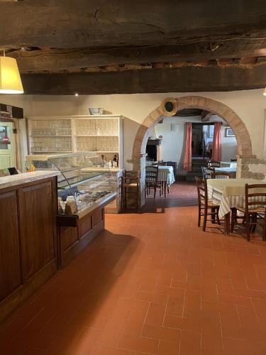 a restaurant with a counter and tables and chairs at Locanda Del Viandante B&B in Anghiari