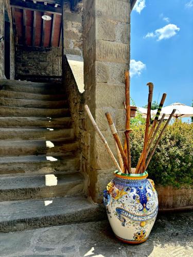a vase with sticks in it next to a staircase at Locanda Del Viandante B&B in Anghiari