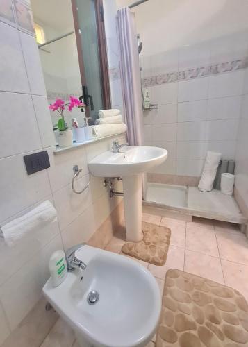 a white bathroom with a sink and a shower at Ma Maison Etnea in Catania