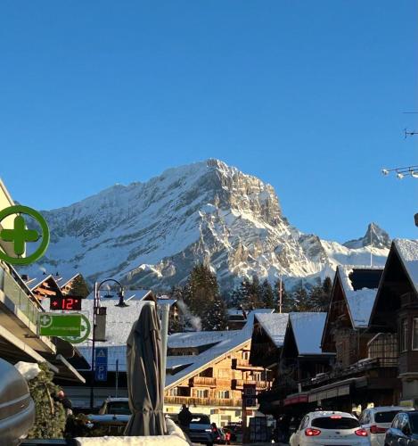 a mountain in the background of a town with snow at Central studio in Villars sur Ollon, Emeraude, for 3 only 100m to Bretaye ski train in Villars-sur-Ollon