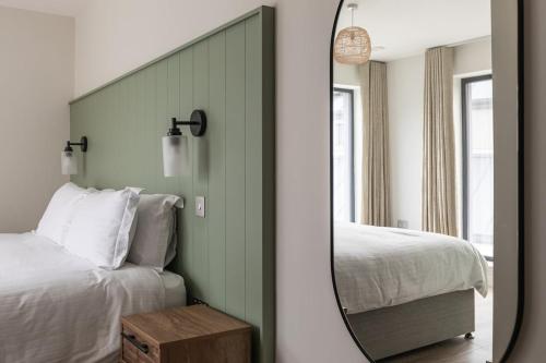 a mirror in front of a bedroom with a bed at Leenan at Ballyliffin Beach Houses, Pollan Bay in Ballyliffin