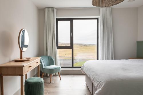 a bedroom with a bed and a desk and a window at Leenan at Ballyliffin Beach Houses, Pollan Bay in Ballyliffin