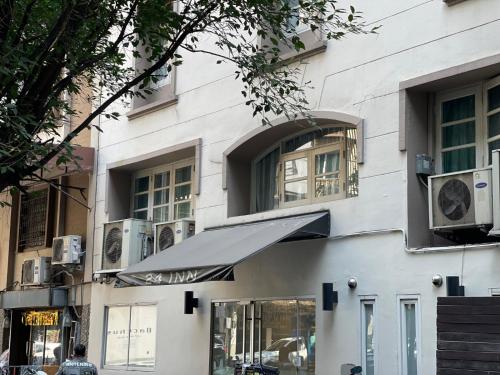 a white building with an awning in front of it at 24 Inn at BTS Phrom Phong in Bangkok