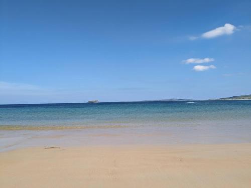 a sandy beach with the ocean in the background at Leenan at Ballyliffin Beach Houses, Pollan Bay in Ballyliffin