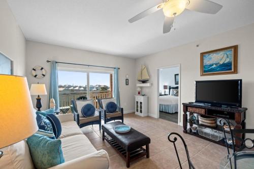 a living room with a couch and a flat screen tv at Waterside Village by Panhandle Getaways in Mexico Beach