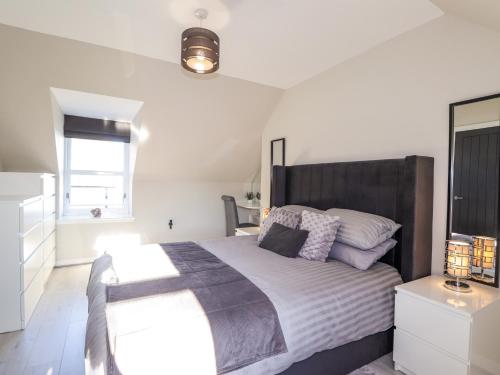 a bedroom with a large bed and a window at 3 The Granary in Banff