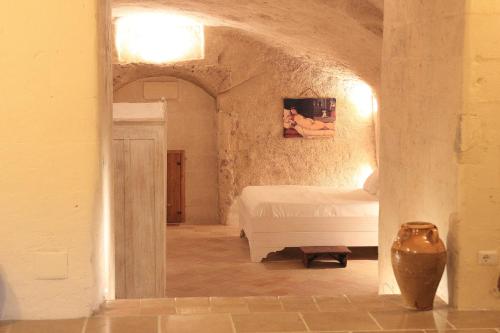 1 dormitorio con 1 cama blanca en una habitación en La Neviera nei Sassi, en Matera