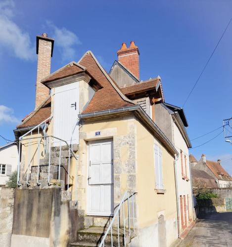 une vieille maison avec deux cheminées dans une rue dans l'établissement Le refuge du Marinier, à Saint-Satur