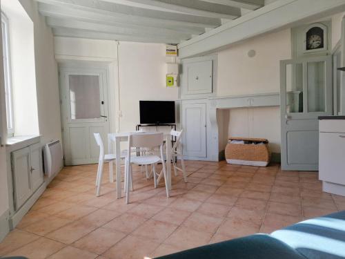 une cuisine avec une table et des chaises dans une pièce dans l'établissement Le refuge du Marinier, à Saint-Satur