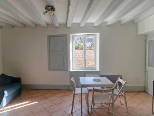 une salle à manger avec une table et des chaises et une fenêtre dans l'établissement Le refuge du Marinier, à Saint-Satur