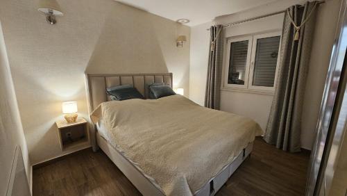 Un dormitorio con una cama grande con almohadas azules. en Apartman SeaShell, en Primošten